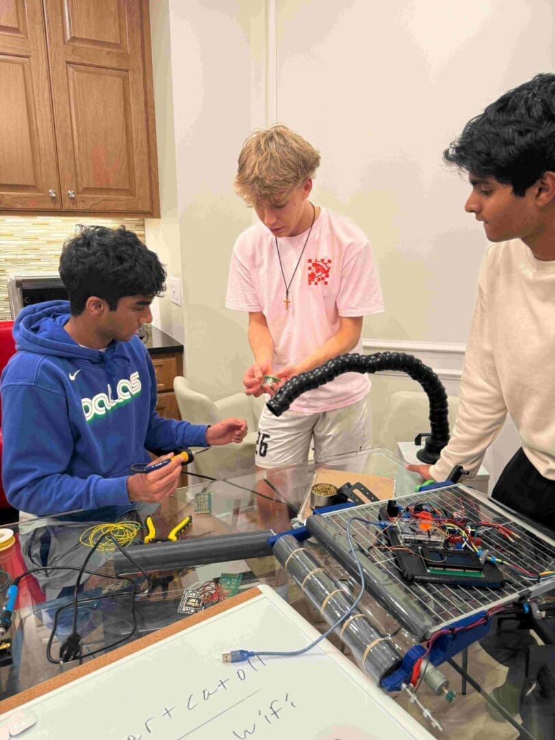 Three boys are working on a project together.