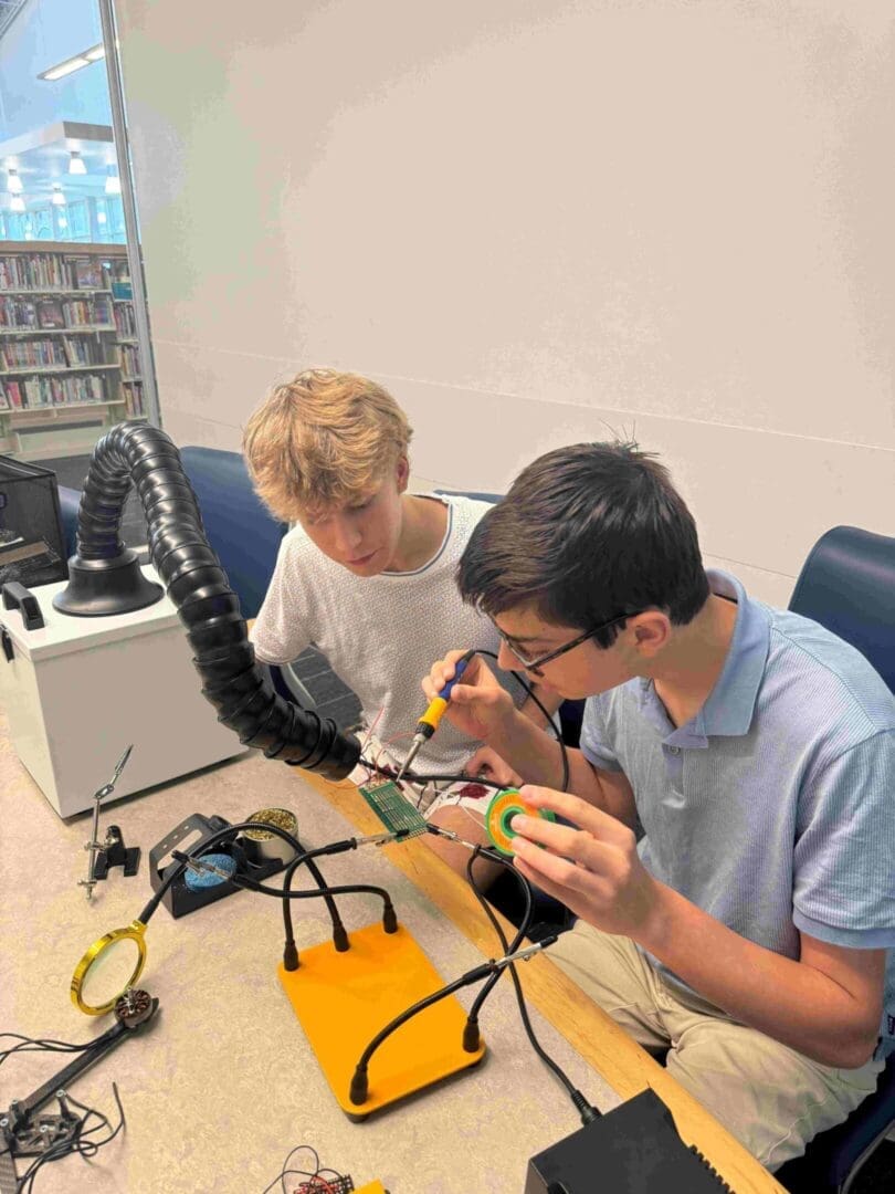 Two boys are working on a project together.