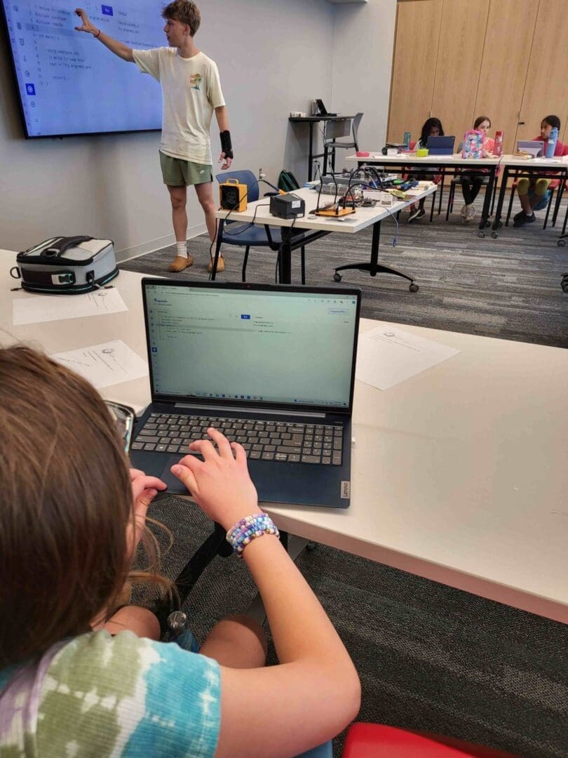 A girl is sitting at the table with her laptop.