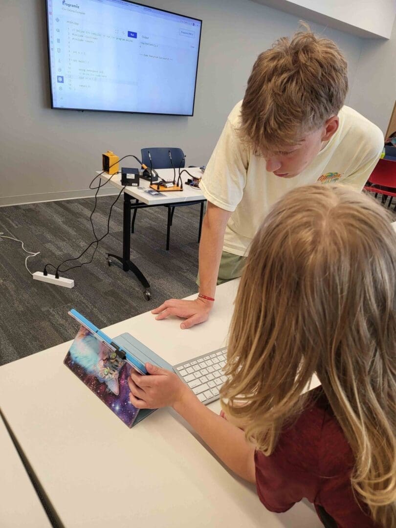 Two children are playing on a tablet computer.