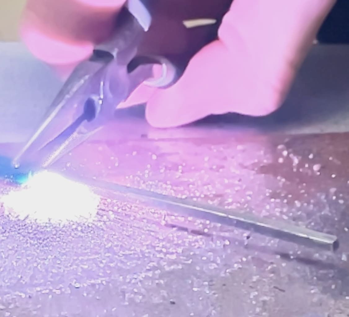 Welding metal with pliers.